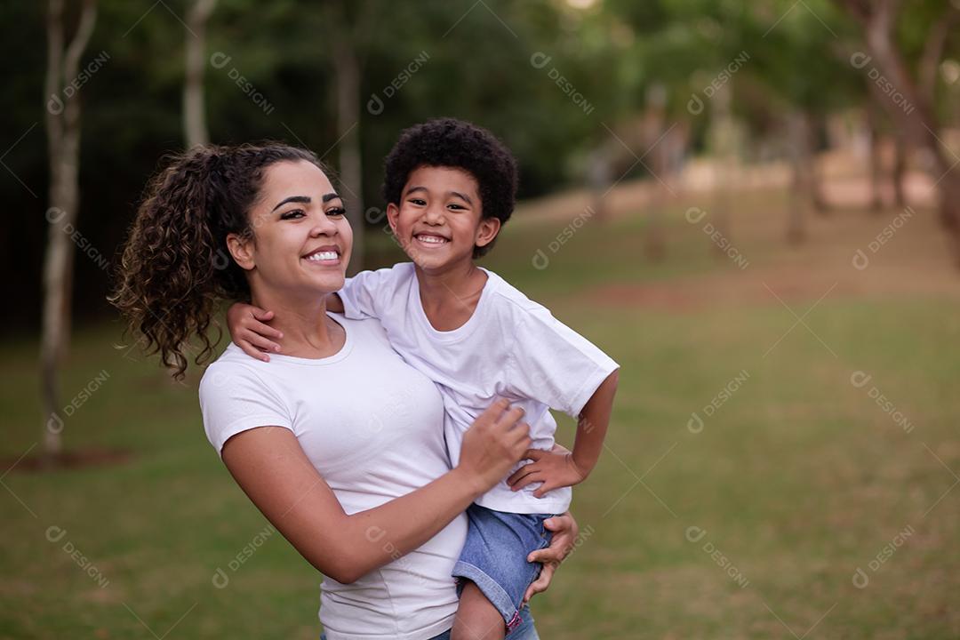 mãe e filho afro no parque sorrindo para a câmera