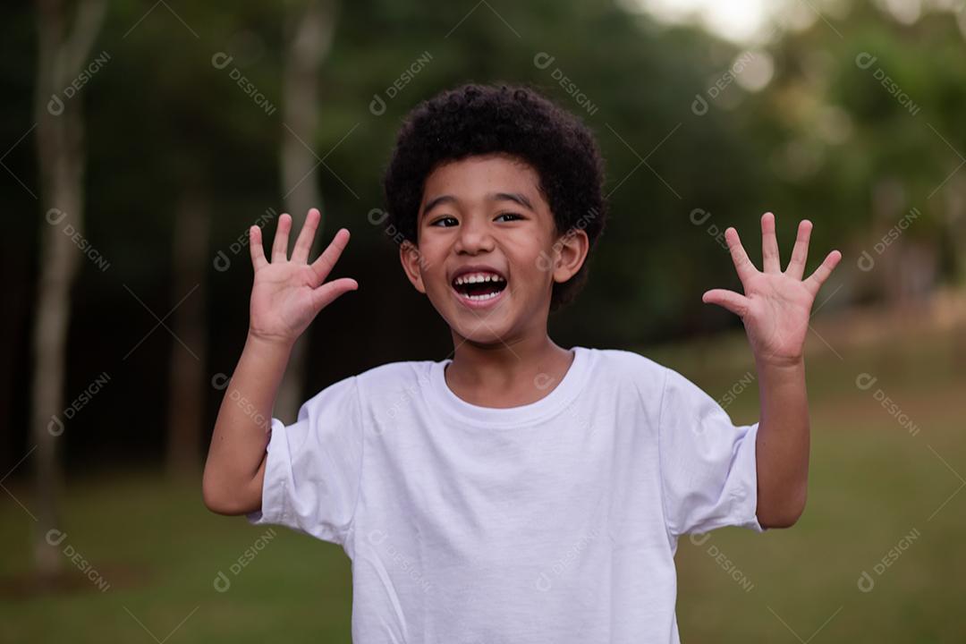 menino afro fazendo careta mostrando as mãos para a câmera