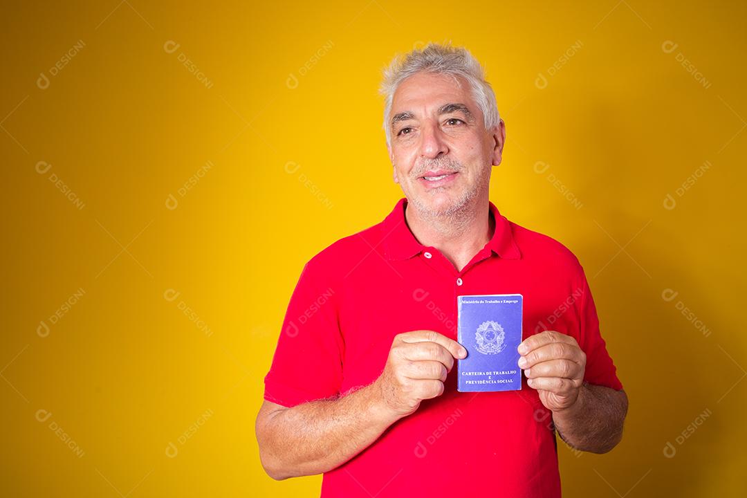 homem idoso segurando um cartão de trabalho brasileiro