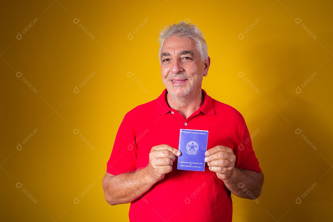 homem idoso segurando um cartão de trabalho brasileiro
