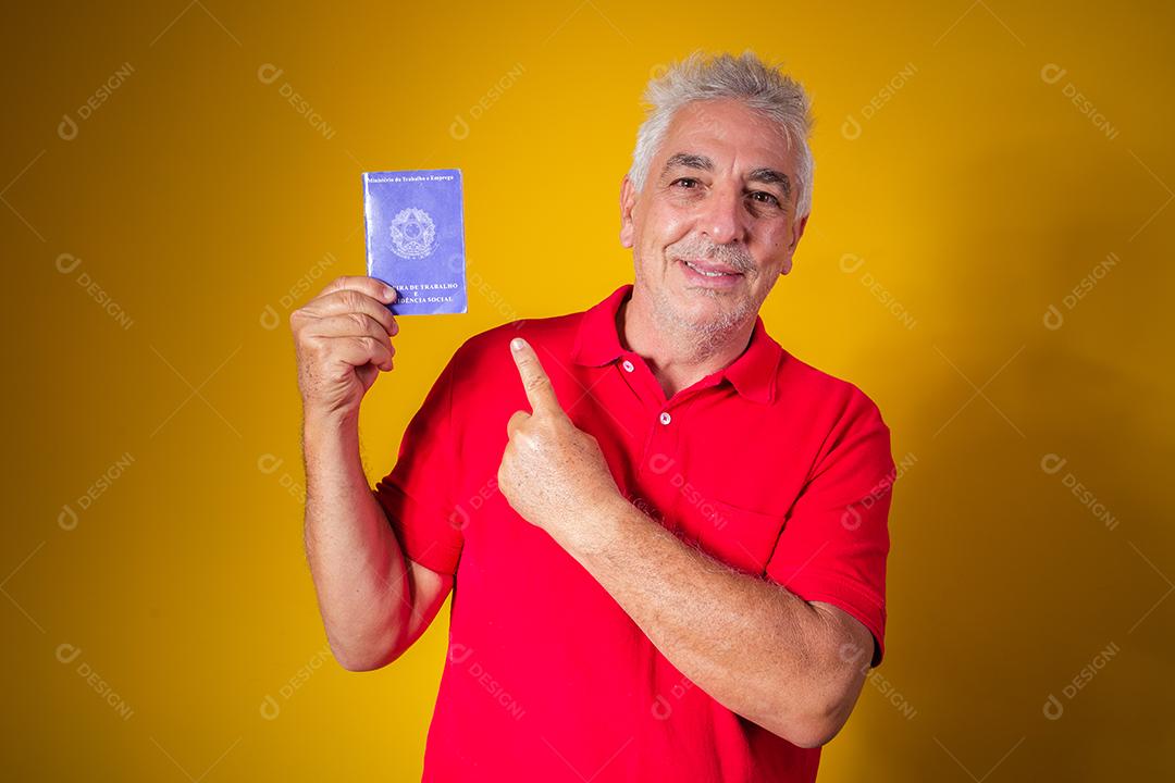 homem idoso segurando um cartão de trabalho brasileiro
