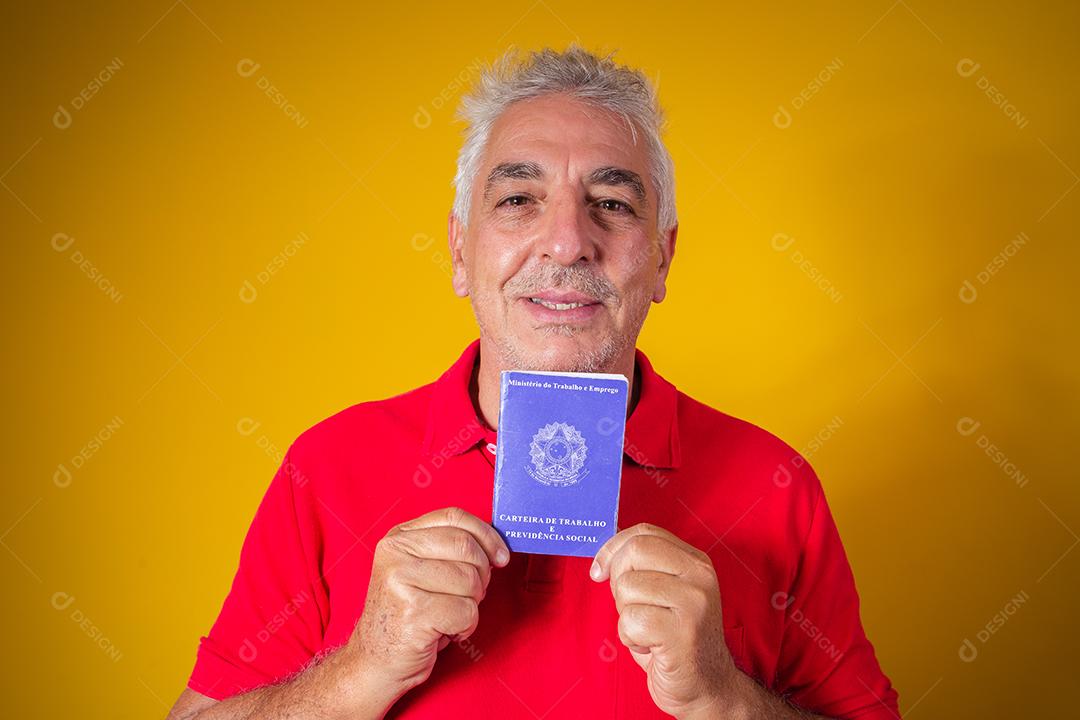 homem idoso segurando um cartão de trabalho brasileiro