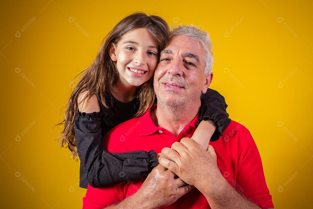 Menina linda criança com seu pai mais velho em fundo amarelo. Dia dos Pais