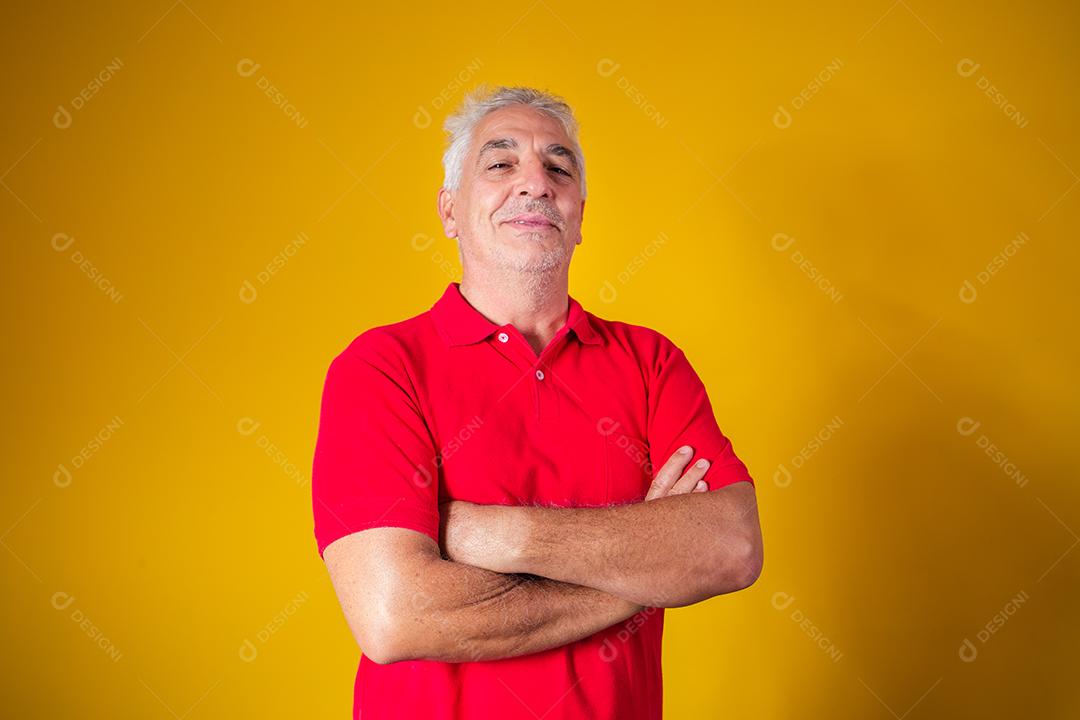 homem idoso olhando para a câmera em fundo amarelo