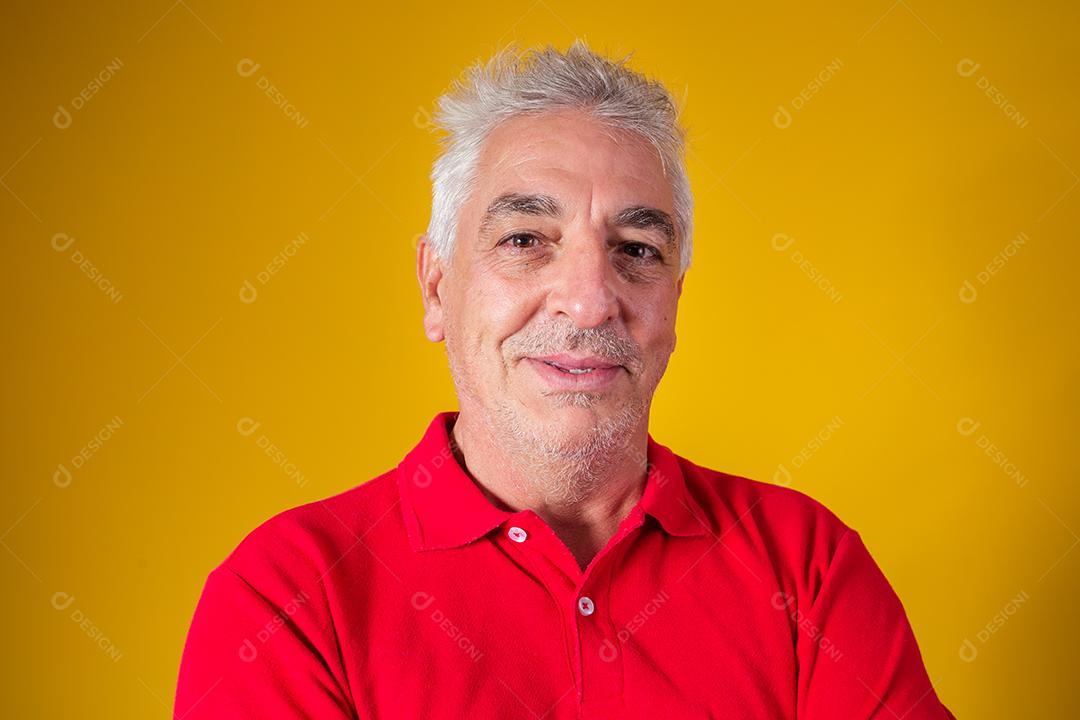 homem idoso olhando para a câmera em fundo amarelo