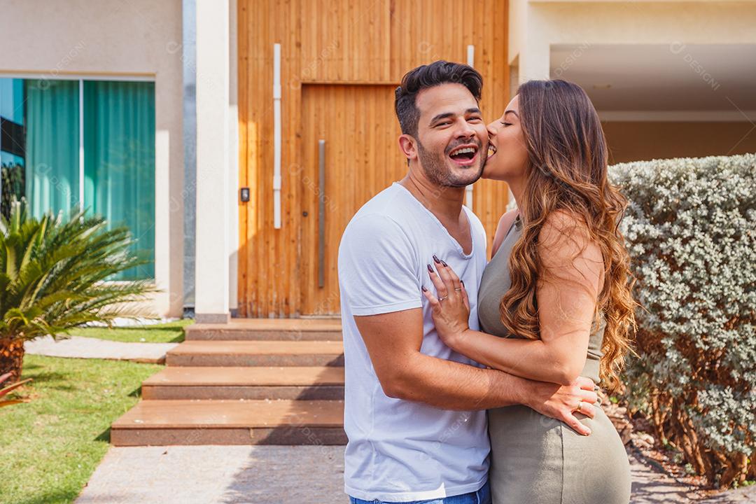 Casal abraçados em frente de casa felizes Imagem