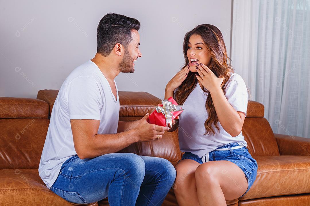 Homem e mulher casal sentado no sofá ganhando presente