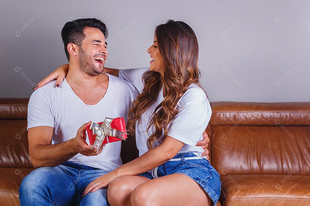 Homem e mulher casal sentado no sofá ganhando presente