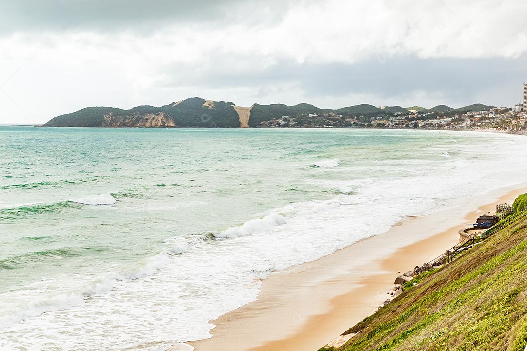 Paisagem de montanhas e mar com arreia e sol forte