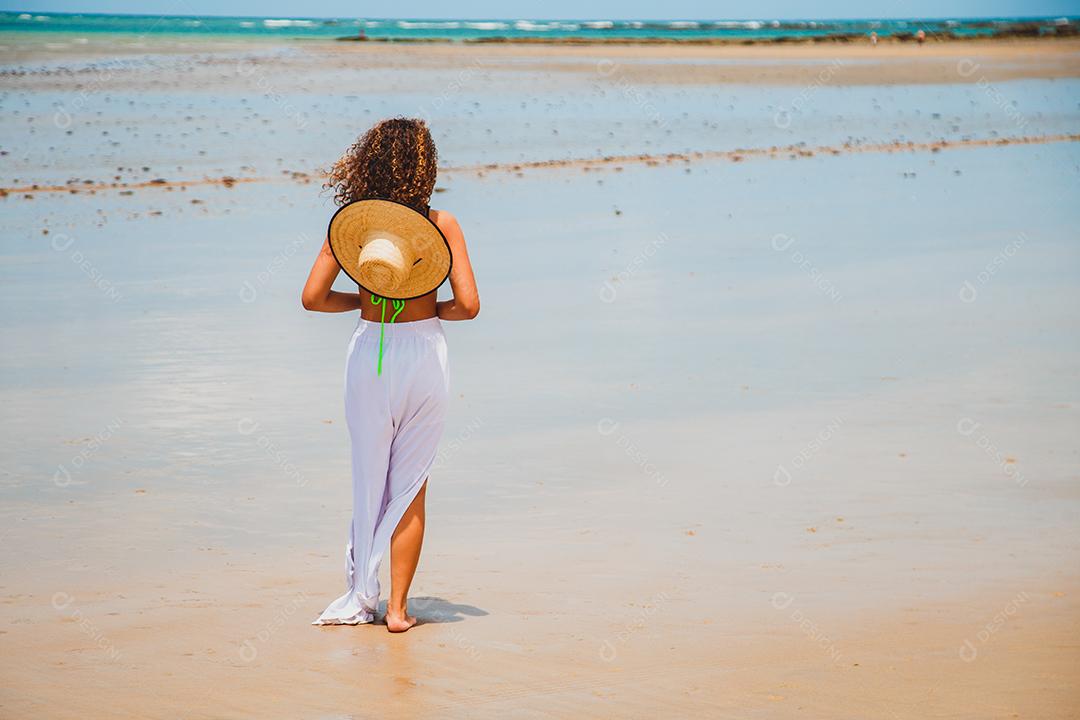 Linda mulher afro brasileira em uma praia no rio grande do norte, sorriu, sentindo a liberdade e as ondas do mar
