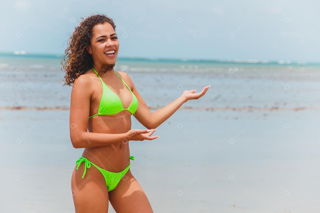 Linda mulher afro brasileira em uma praia no rio grande do norte, sorriu, sentindo a liberdade e as ondas do mar