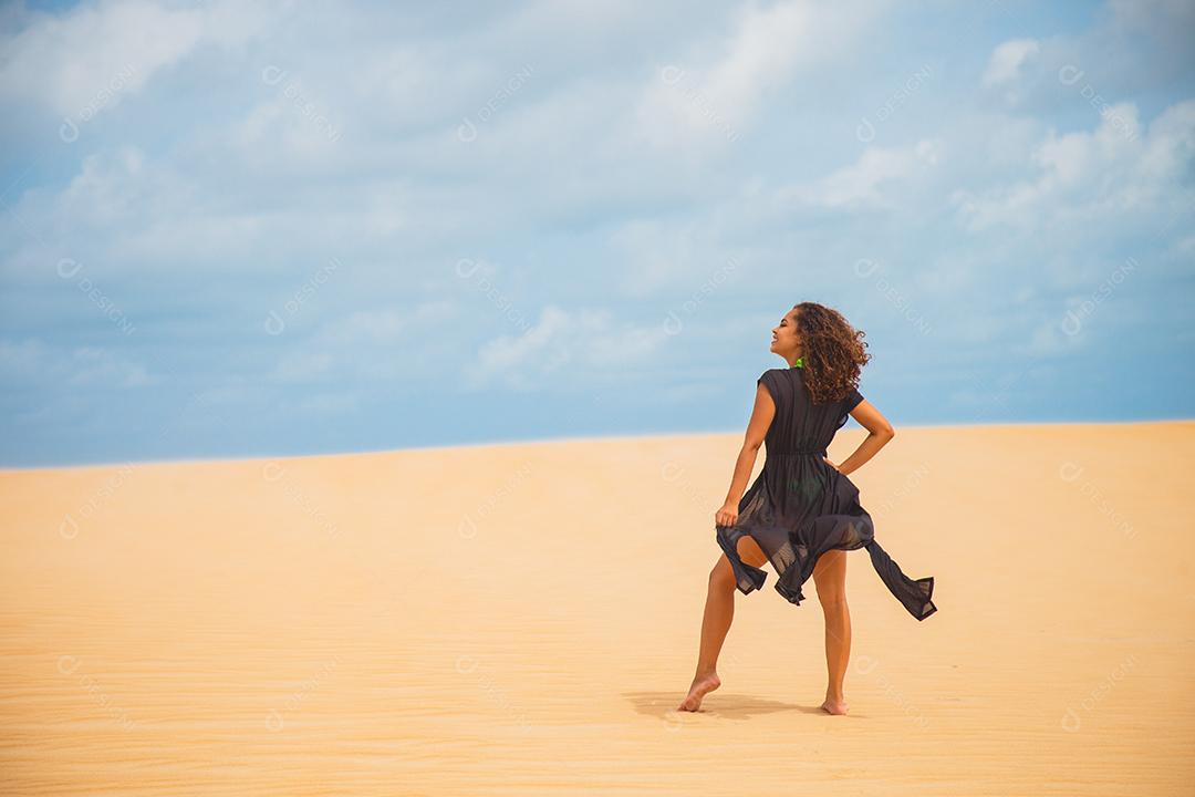 Mulher jovem e bonita posando na areia do deserto