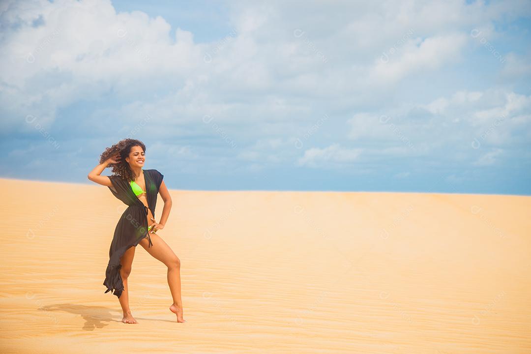 Mulher jovem e bonita posando na areia do deserto