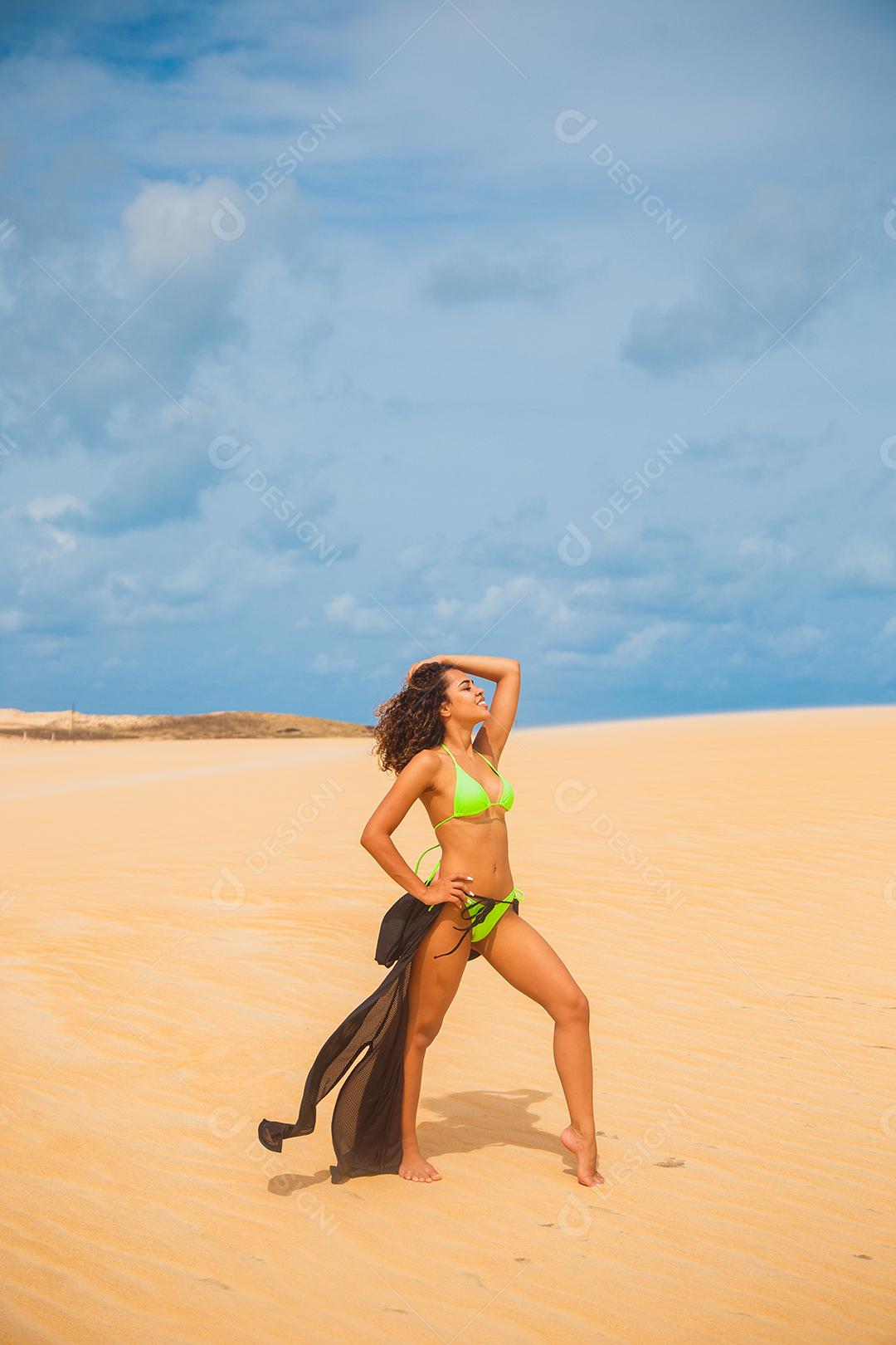 Mulher jovem e bonita posando na areia do deserto