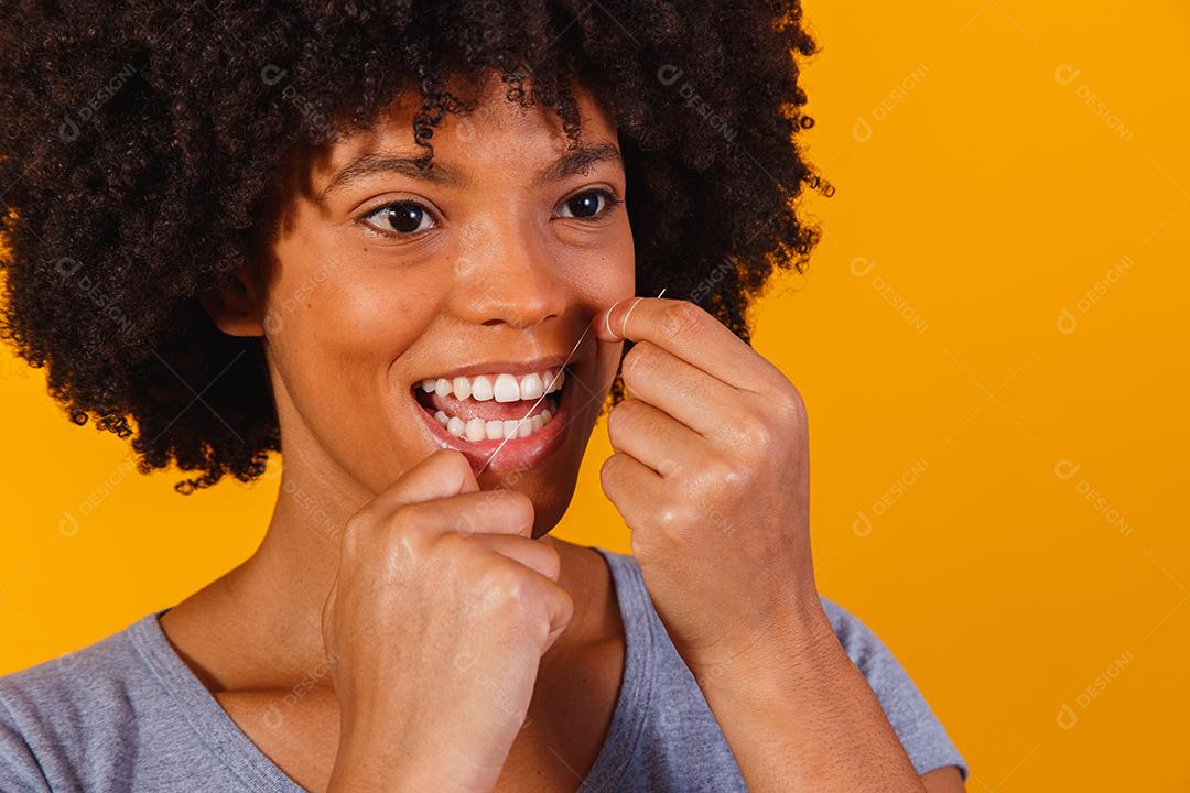 afro woman flossing her teeth. oral health concept