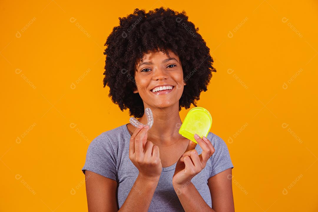 mulher afro segurando placa de clareamento. Dispositivo invisível.