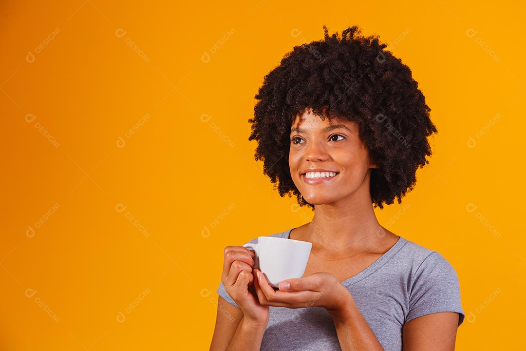 Mulher Afro tomando chá em fundo amarelo