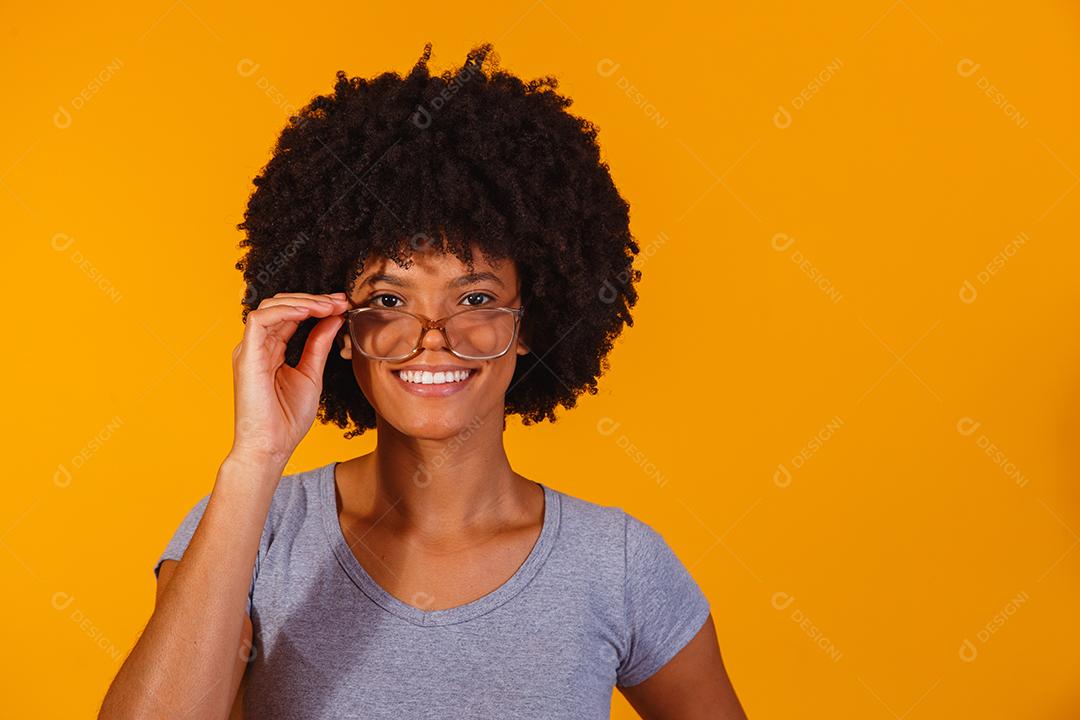 mulher afro com óculos sorrindo para a câmera