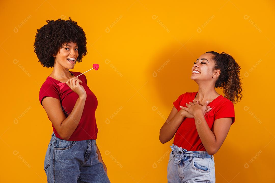 casal de lésbicas afro em fundo amarelo. casal homoafetivo