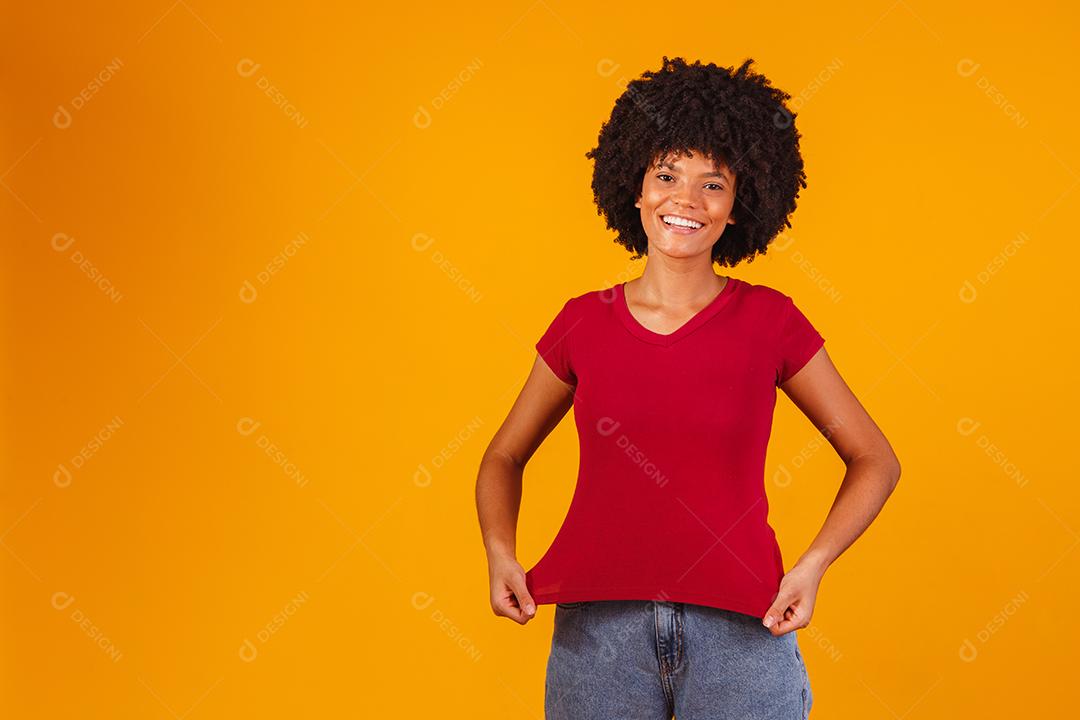 Mulher afro apontando para t-shirt