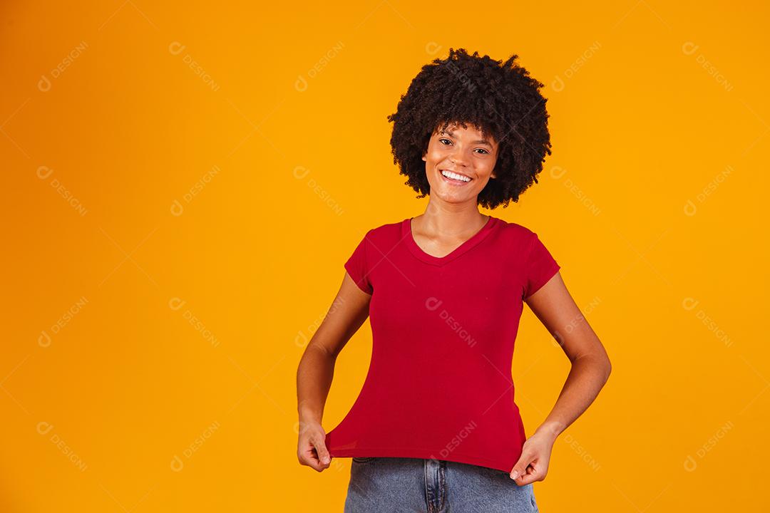 Mulher afro apontando para t-shirt