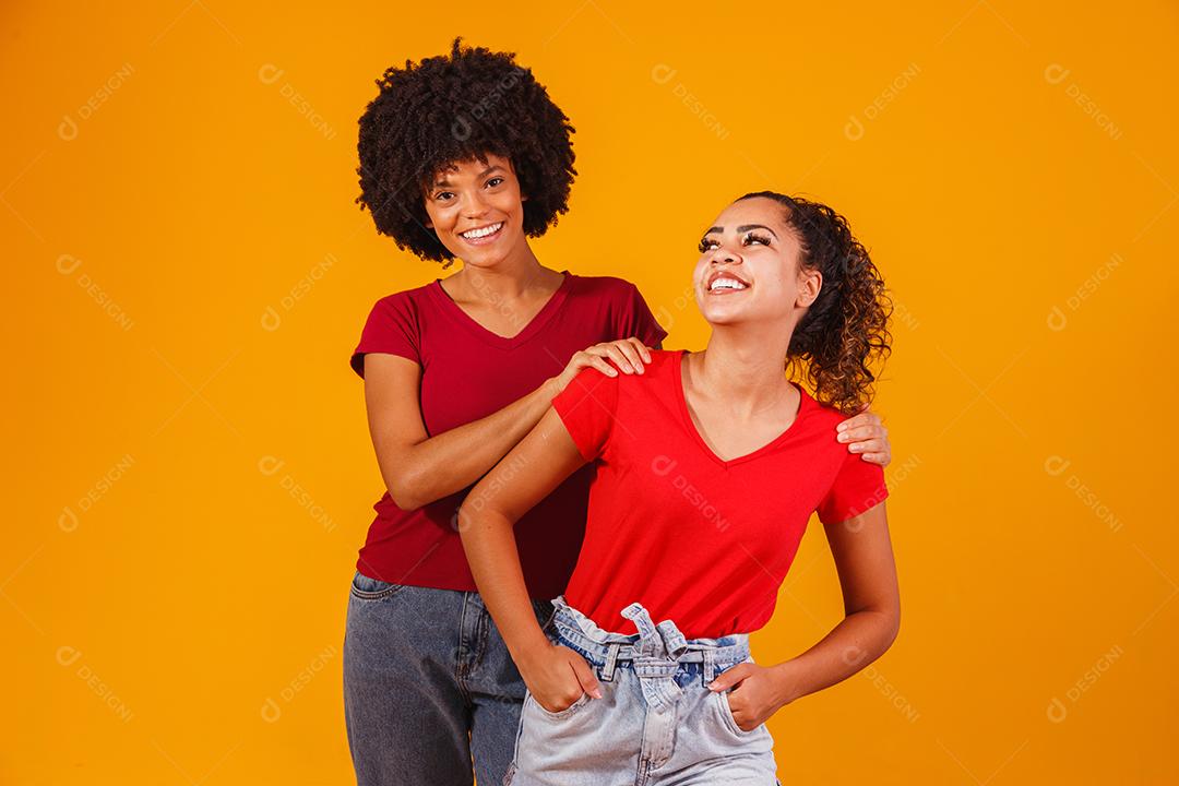Jovens amigas afro bonitas e felizes sorrindo para a câmera.