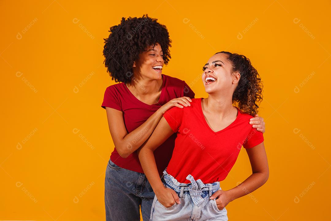 Jovens amigas afro bonitas e felizes sorrindo para a câmera.