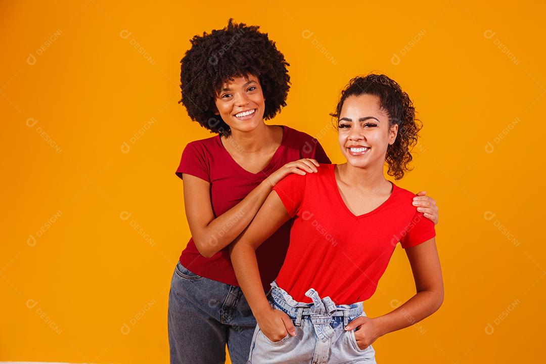 Jovens amigas afro bonitas e felizes sorrindo para a câmera.