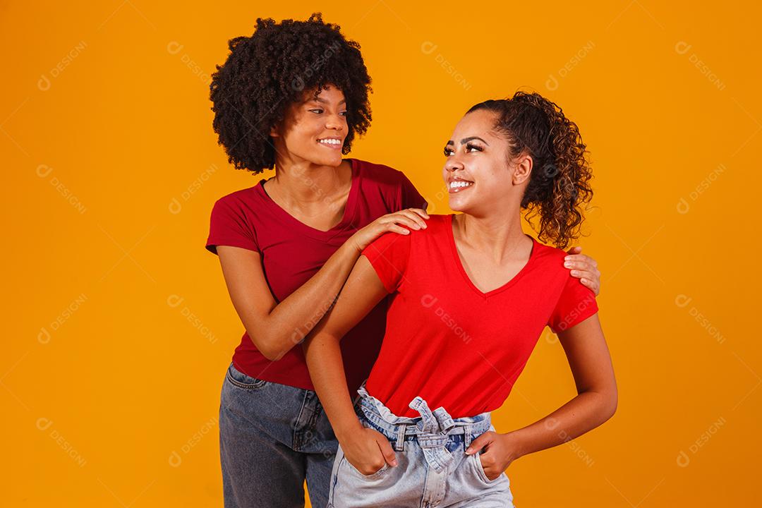 Jovens amigas afro bonitas e felizes sorrindo para a câmera.