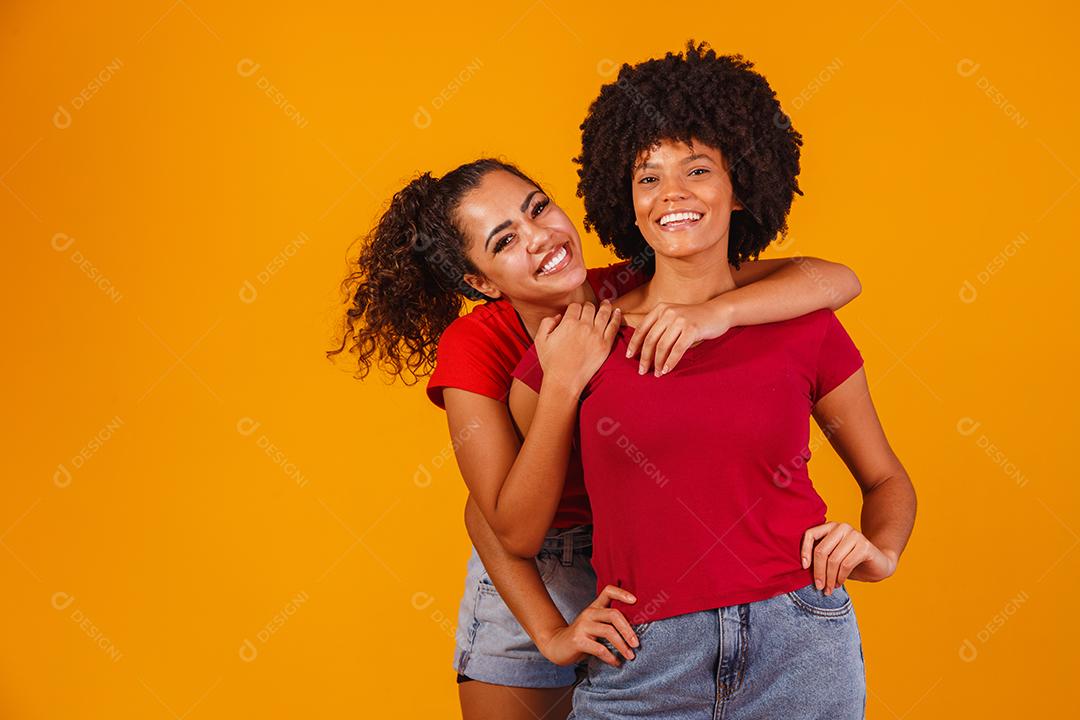 Jovens amigas afro bonitas e felizes sorrindo para a câmera.