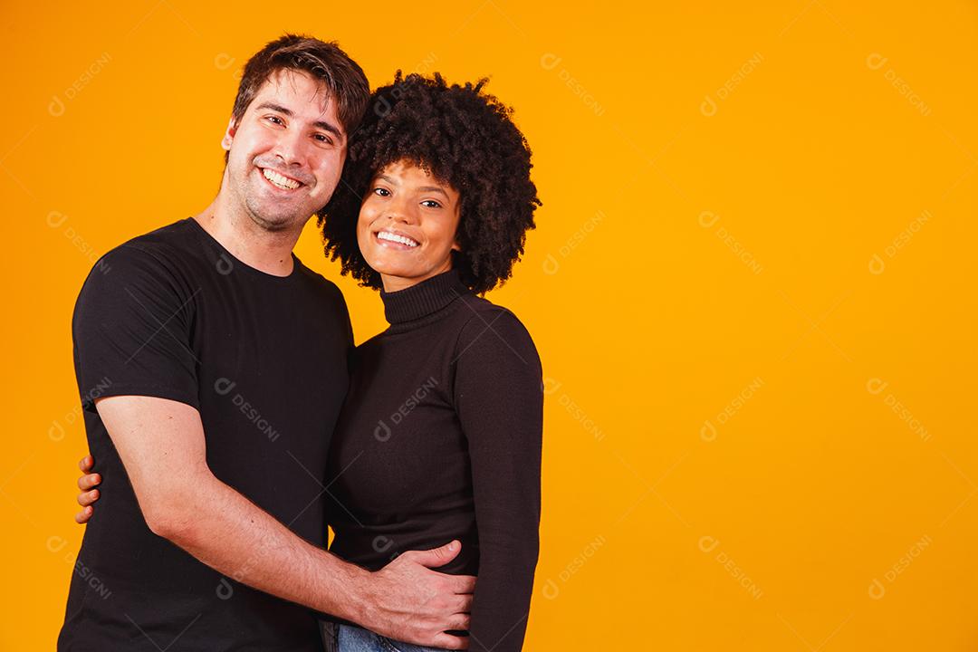 Retrato de casal de conteúdo em roupas básicas sorrindo para a câmera