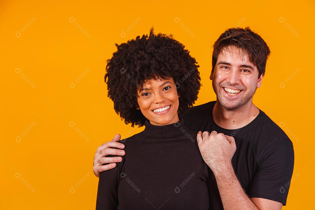 Retrato de casal de conteúdo em roupas básicas sorrindo para a câmera
