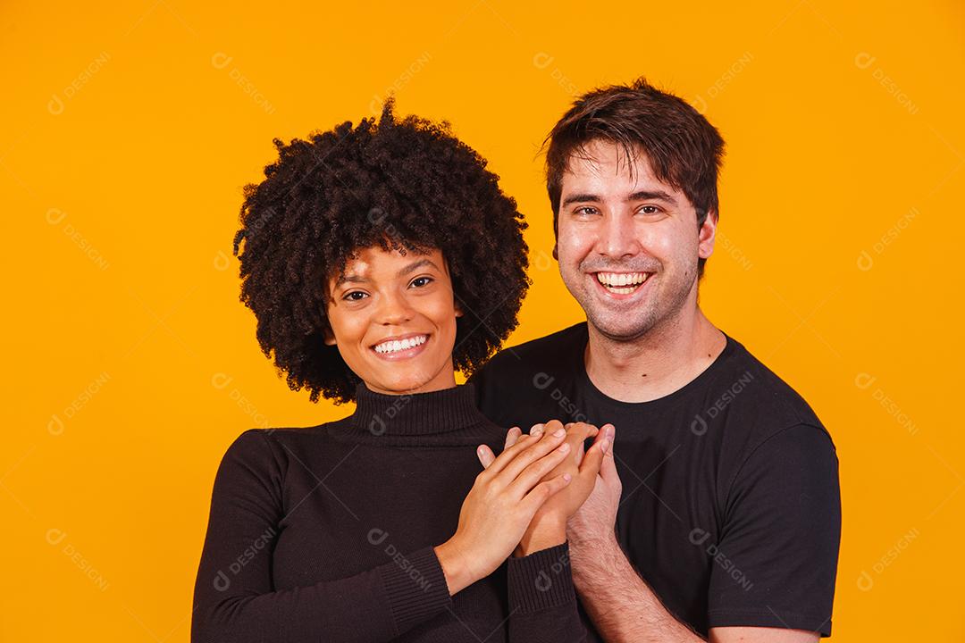 Retrato de casal de conteúdo em roupas básicas sorrindo para a câmera