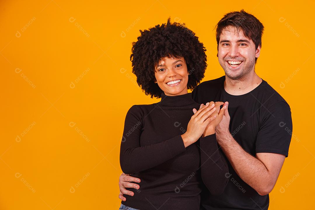 Retrato de casal de conteúdo em roupas básicas sorrindo para a câmera