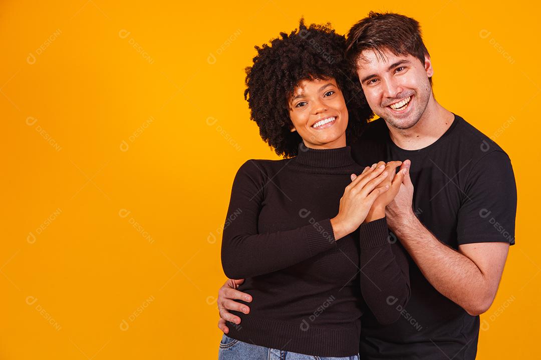 Retrato de casal de conteúdo em roupas básicas sorrindo para a câmera