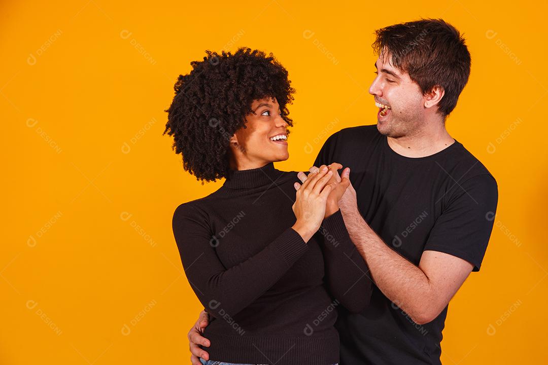 Retrato de casal de conteúdo em roupas básicas sorrindo para a câmera