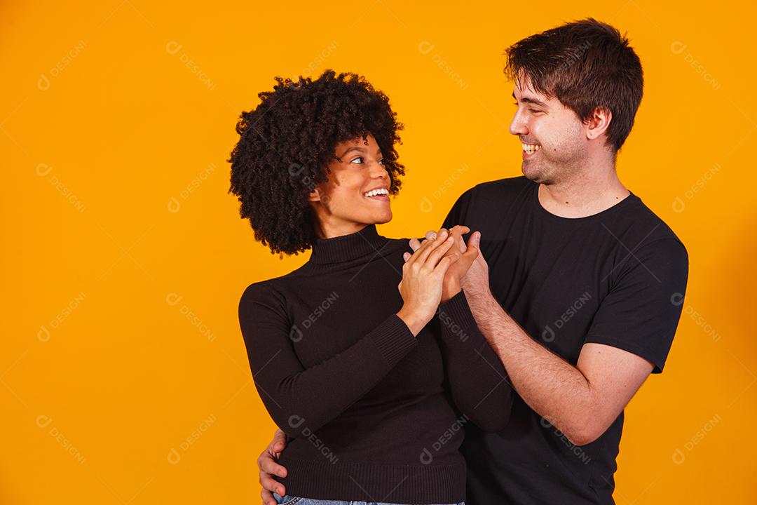 Portrait of content couple in basic clothing smiling at camera