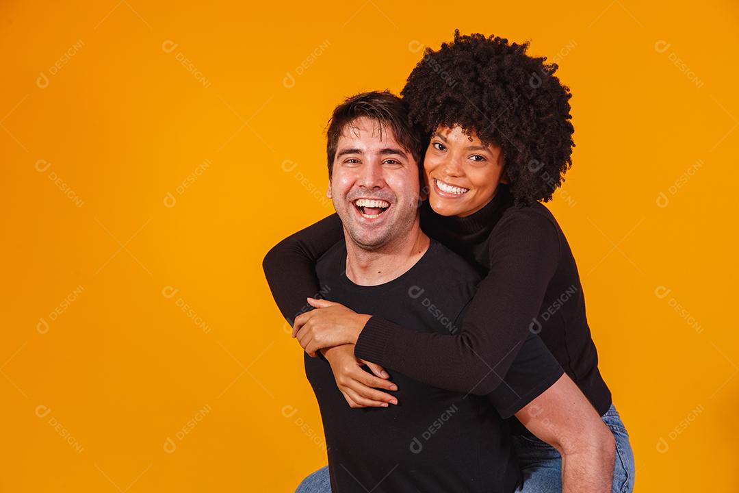 Retrato de casal de conteúdo em roupas básicas sorrindo para a câmera