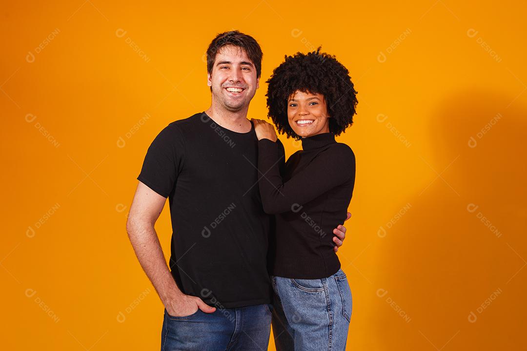 Retrato de casal de conteúdo em roupas básicas sorrindo para a câmera