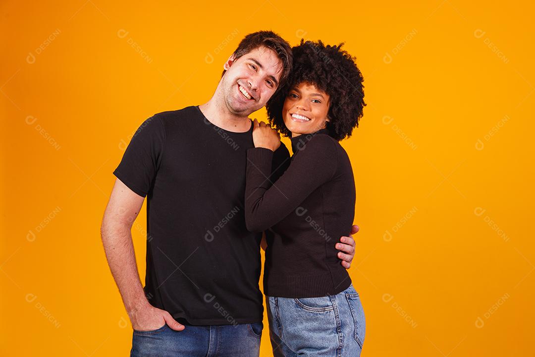 Retrato de casal de conteúdo em roupas básicas sorrindo para a câmera