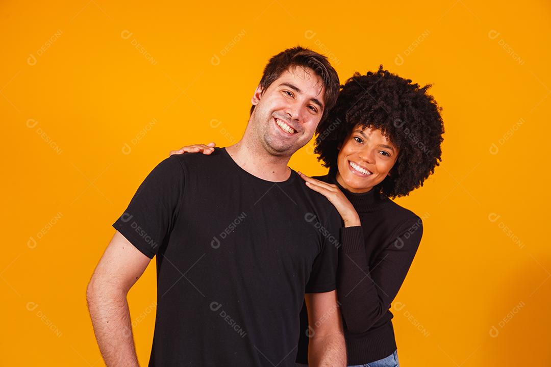 Retrato de casal de conteúdo em roupas básicas sorrindo para a câmera
