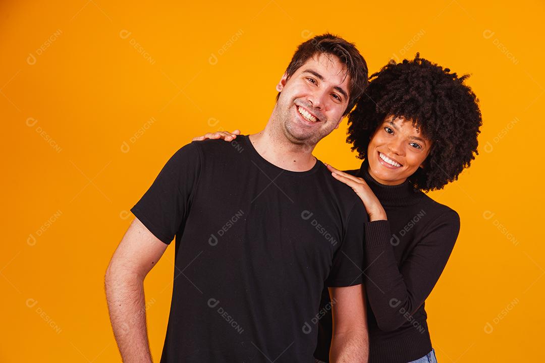 Retrato de casal de conteúdo em roupas básicas sorrindo para a câmera
