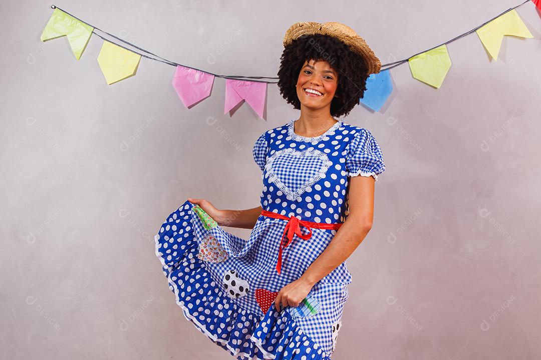 Mulher afro brasileira vestindo roupas típicas para a Festa Junina