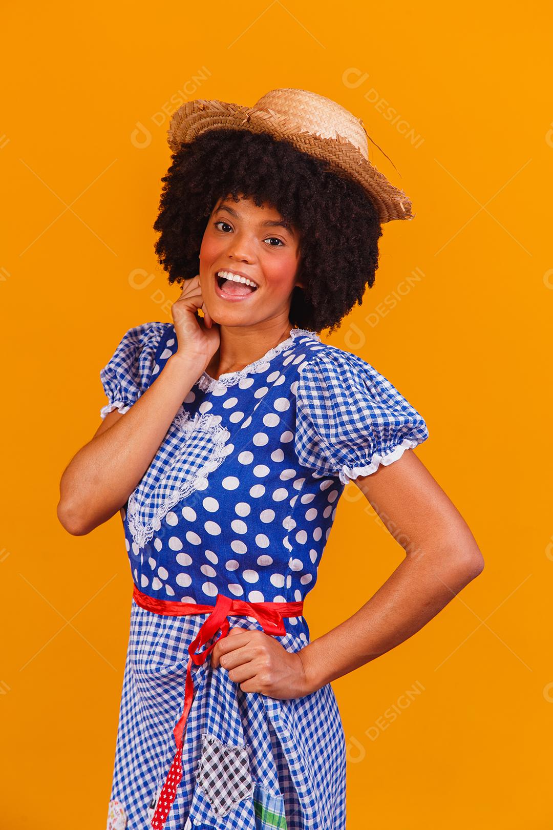 Mulher afro brasileira vestindo roupas típicas para a Festa Junina em fundo amarelo