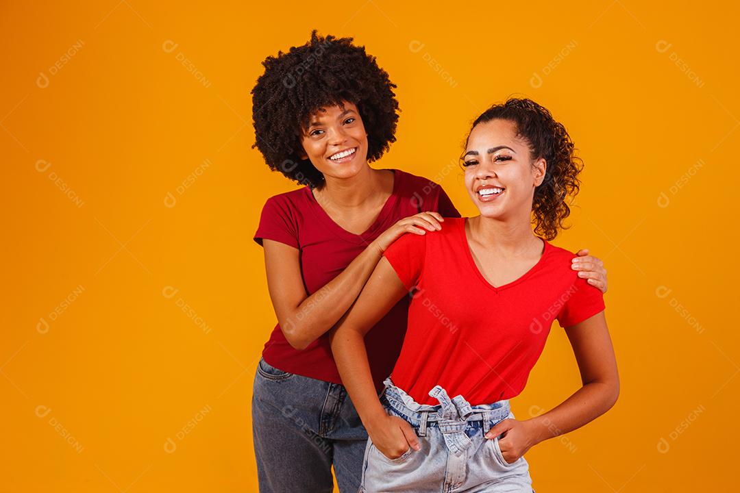Jovens amigas afro bonitas e felizes sorrindo para a câmera.
