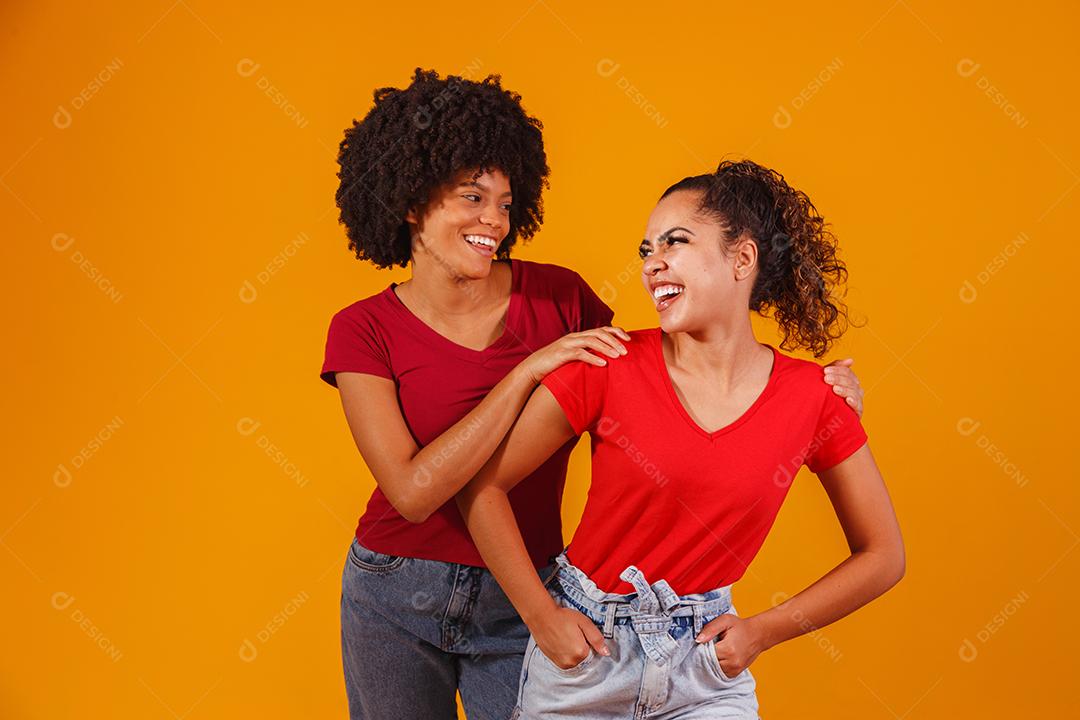 Jovens amigas afro bonitas e felizes sorrindo para a câmera.