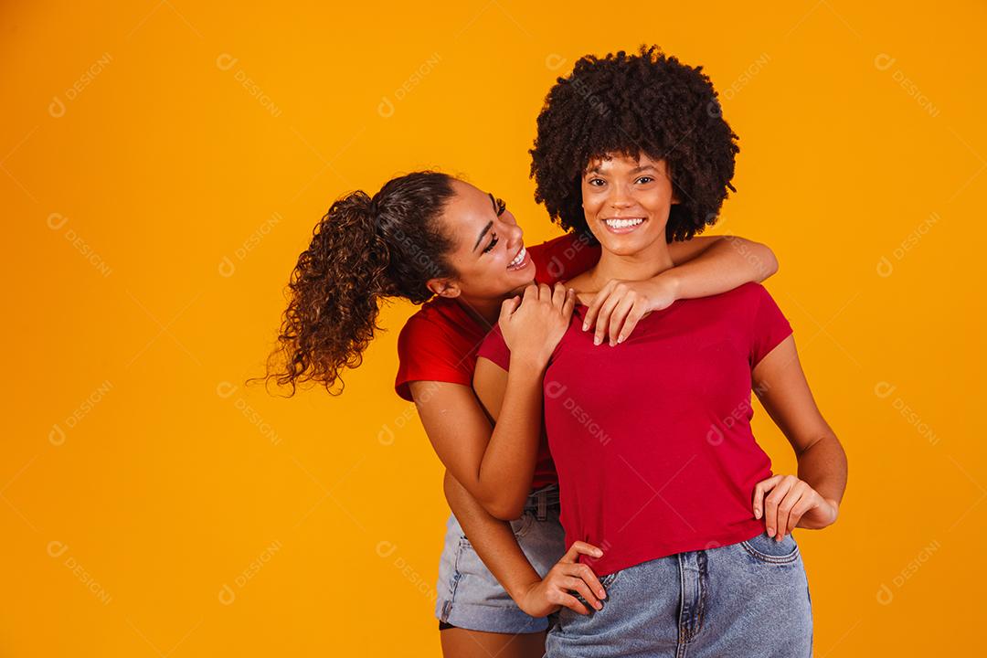 Jovens amigas afro bonitas e felizes sorrindo para a câmera.