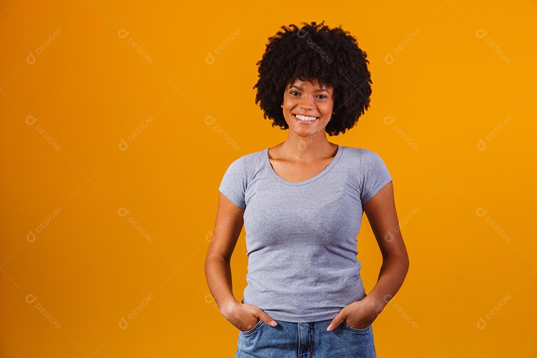 Linda mulher morena cabelo afro com sua mãos no bolso de sua calça