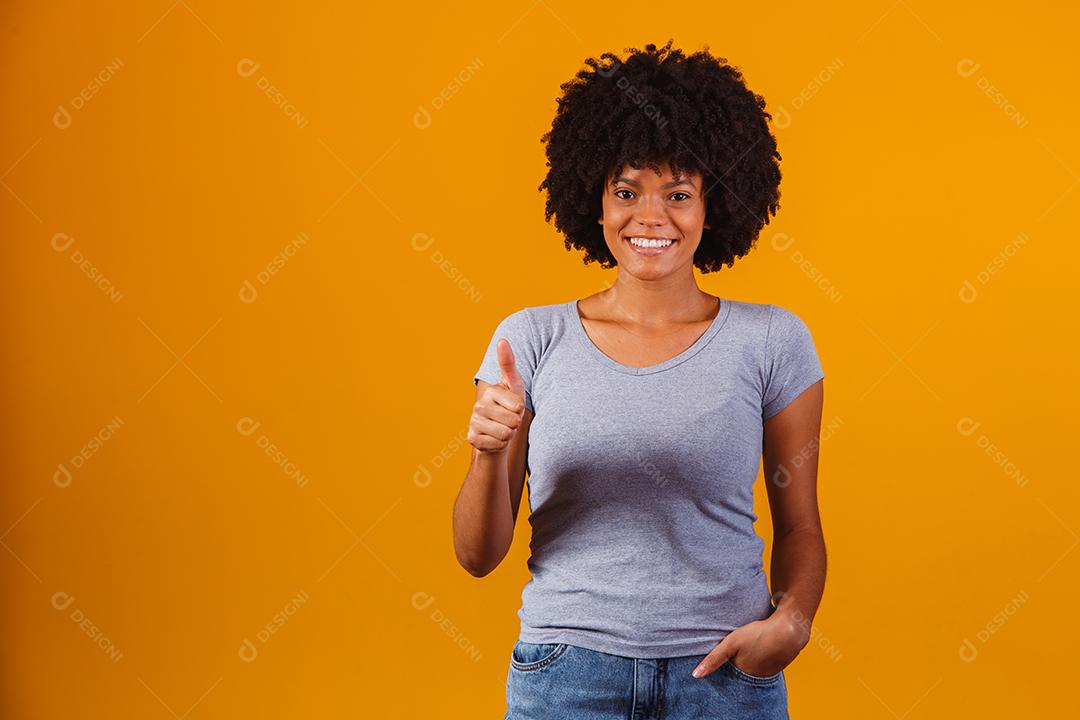 Retrato de sorrir bela jovem afro polegares para cima. menina brasileira.