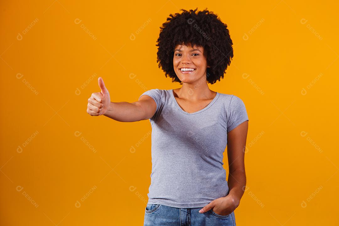 Retrato de sorrir bela jovem afro polegares para cima. menina brasileira.